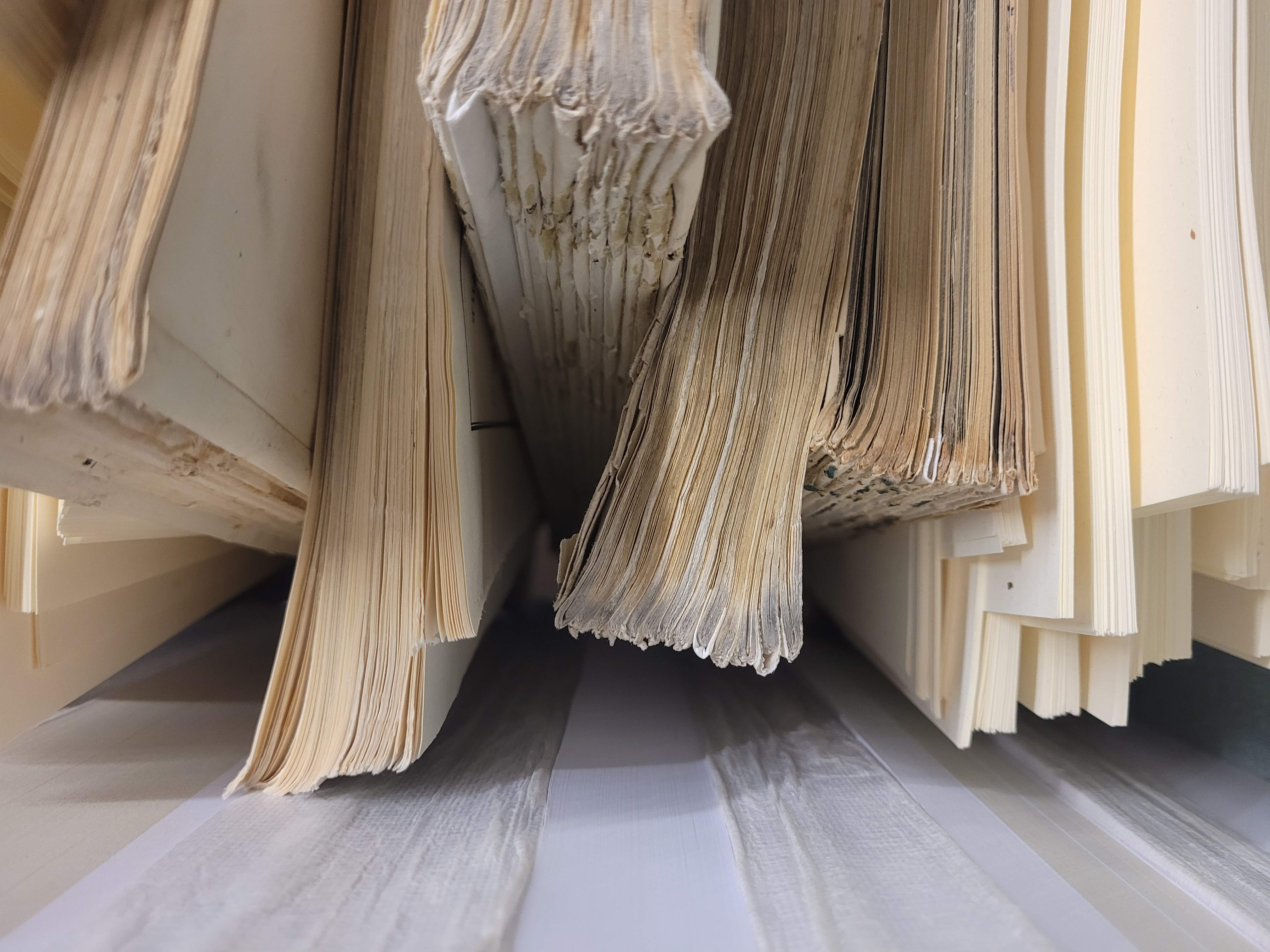 Libri antichi con pagine deteriorate da restaurare